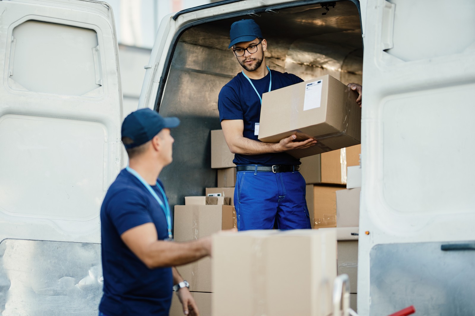 Delivery workers loading packages into cargo van